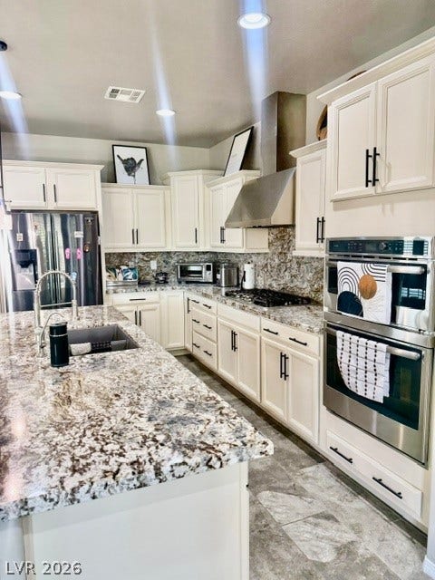 3605 Greenbriar Bluff Avenue, North Las Vegas, NV 89081 Polished stone countertops pair with classic cabinetry and integrated appliances in this timeless kitchen.