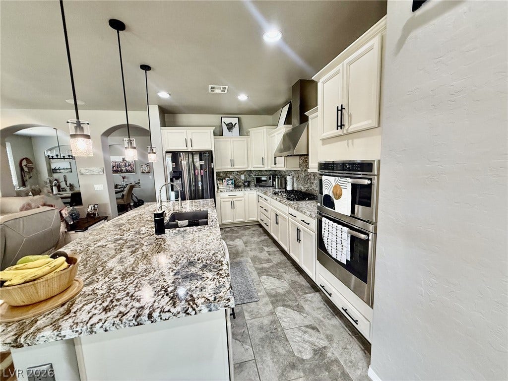 3605 Greenbriar Bluff Avenue, North Las Vegas, NV 89081 An expansive breakfast bar and custom cabinetry define this thoughtfully designed culinary workspace.