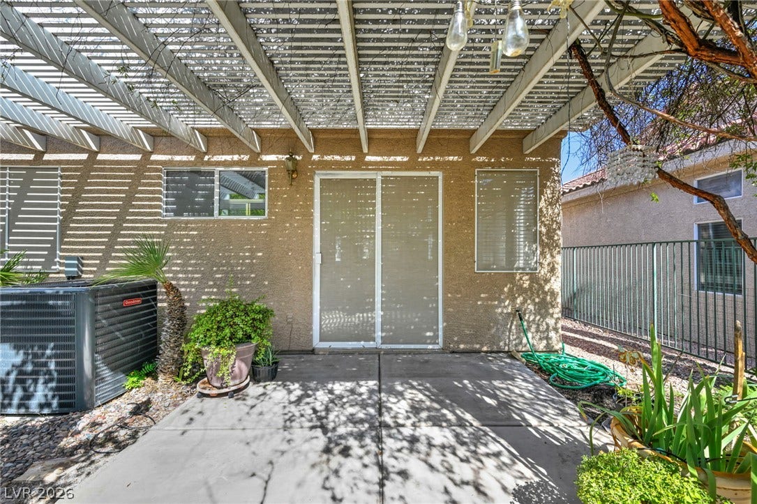 1745 Lily Pond Circle, Henderson, NV 89012 An inviting concrete patio features a protective overhead pergola and sliding glass door access.