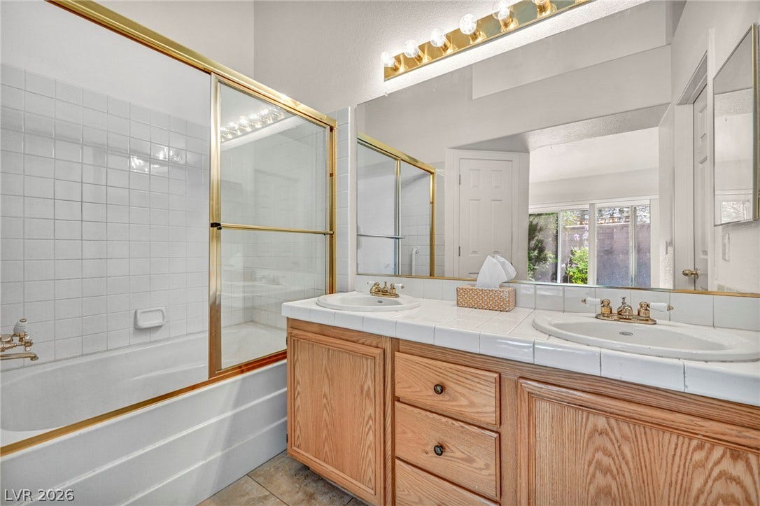 1745 Lily Pond Circle, Henderson, NV 89012 A spacious double vanity and enclosed tub shower highlight this master bathroom design.