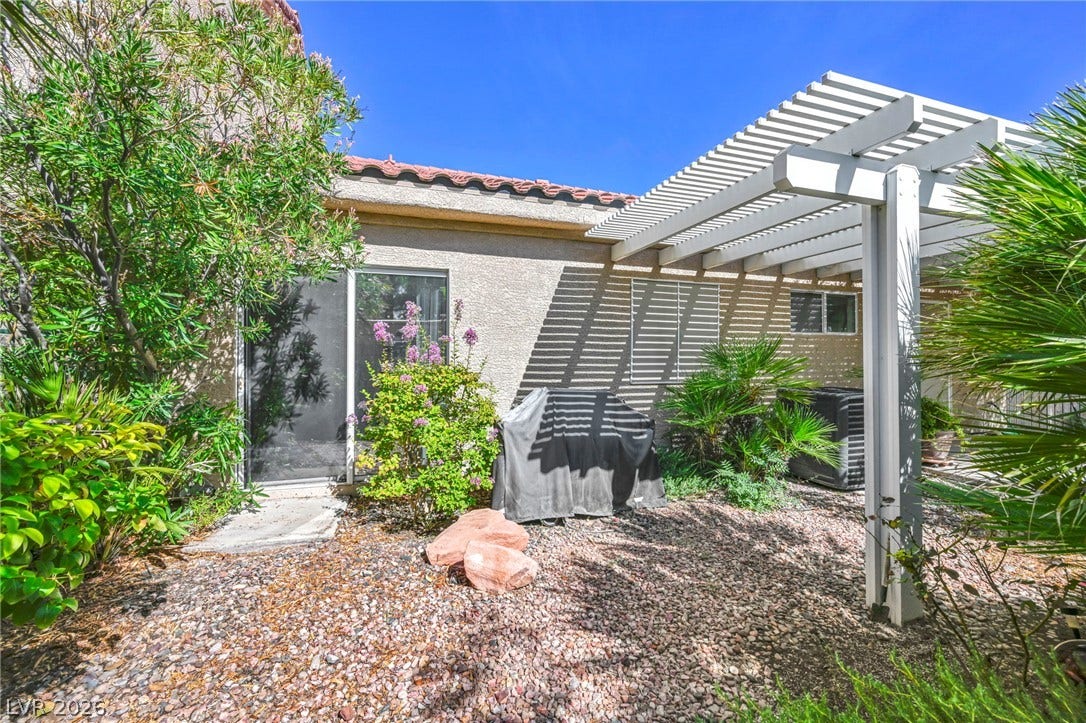 1745 Lily Pond Circle, Henderson, NV 89012 An open pergola casts linear shadows across this low-maintenance gravel yard space.