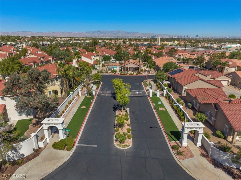 1745 Lily Pond Circle, Henderson, NV 89012 An aerial view showcases a secure, gated entryway leading into a beautifully landscaped residential community.