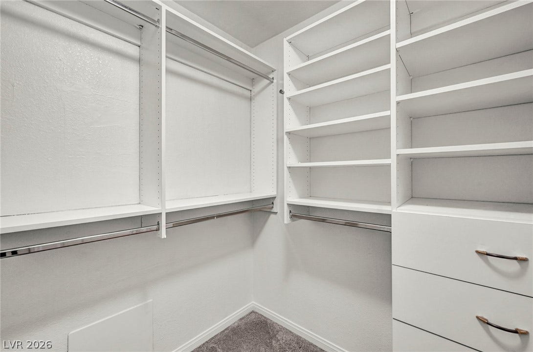1745 Lily Pond Circle, Henderson, NV 89012 Custom built-in shelving and hanging rods maximize storage in this carpeted walk-in closet.