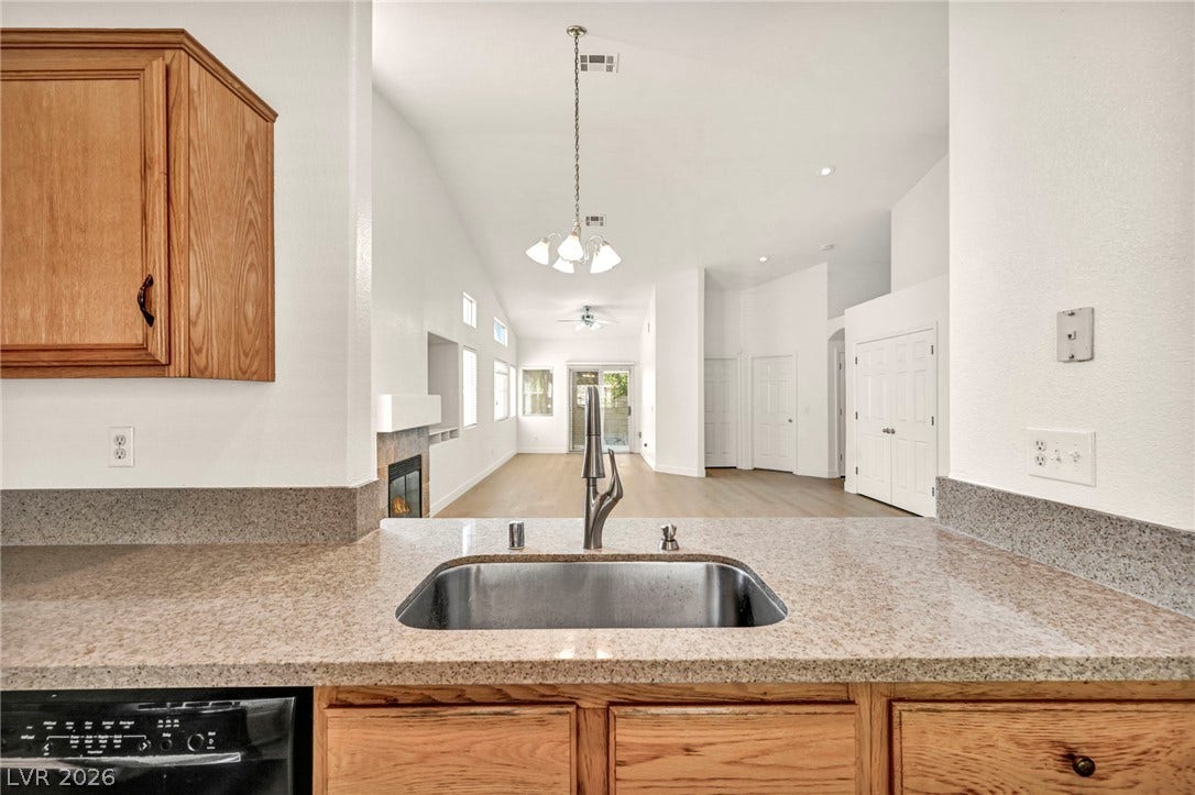 1745 Lily Pond Circle, Henderson, NV 89012 Granite countertops frame a kitchen sink looking out to the open-concept living area.