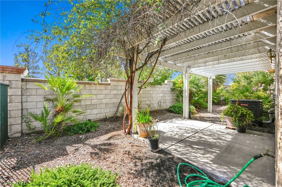 1745 Lily Pond Circle, Henderson, NV 89012 Mature vines wrap around a classic white pergola shading a concrete patio.
