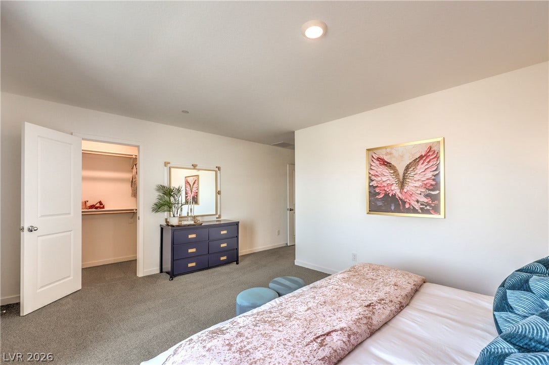 Recessed lighting and soft carpeting create a serene atmosphere in this main-level bedroom.