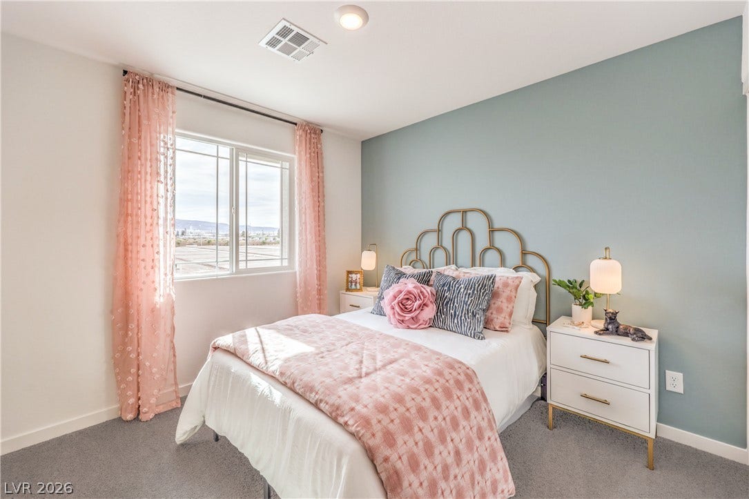 Natural light pours through a large window illuminating the plush carpeted floor.