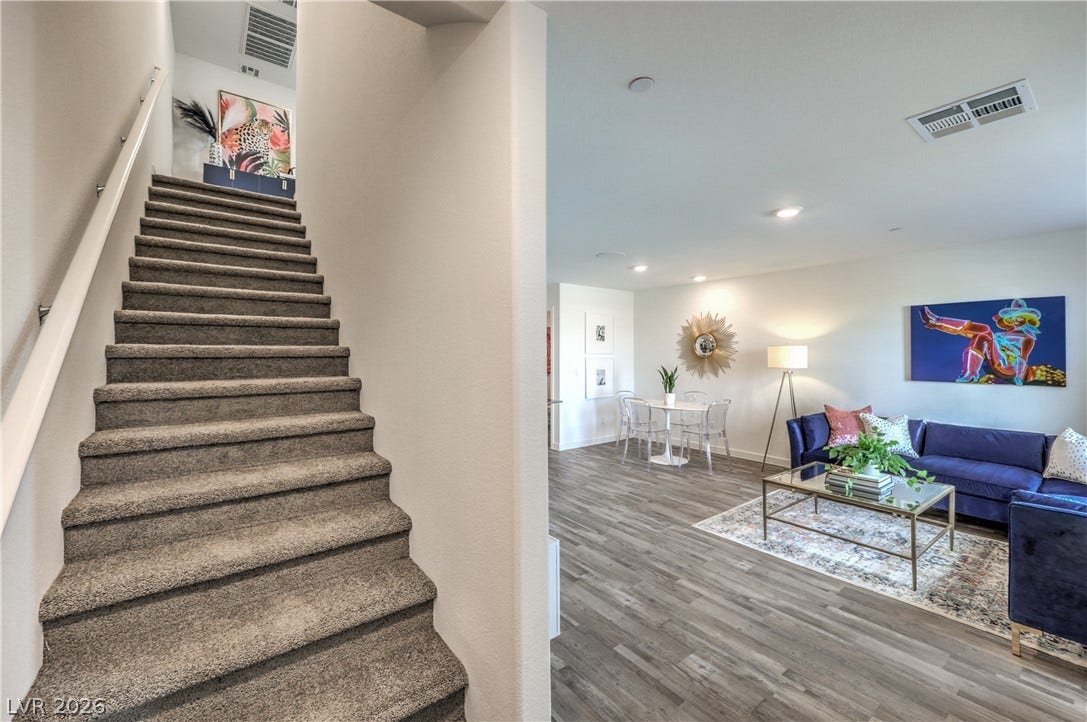 Smooth wood-look flooring and carpeted stairs define this versatile open-concept layout.