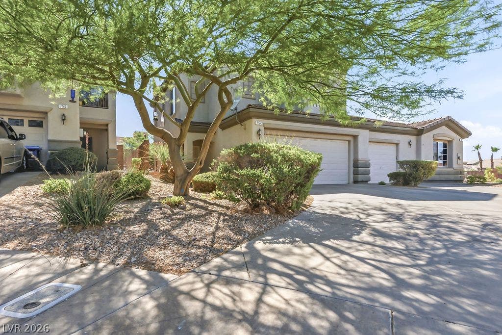 754 Solitude Point Avenue, Henderson, NV 89012 Lush mature trees shade a concrete driveway leading to the multi-car garage.