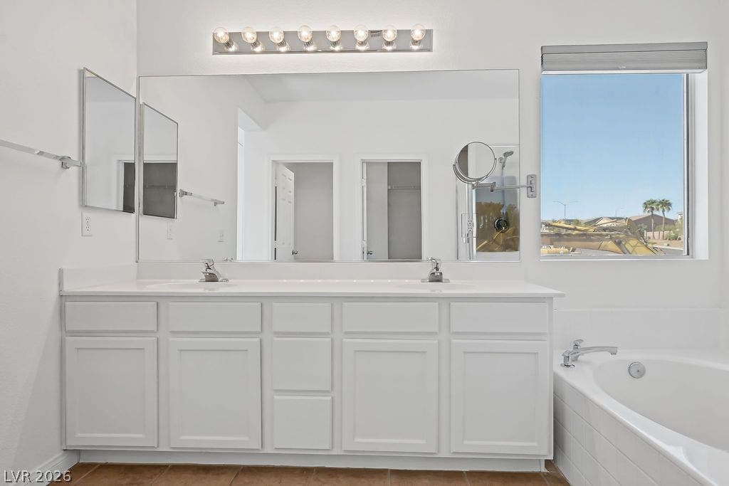 754 Solitude Point Avenue, Henderson, NV 89012 A spacious double vanity and a built-in soaking tub anchor this bright bathroom.