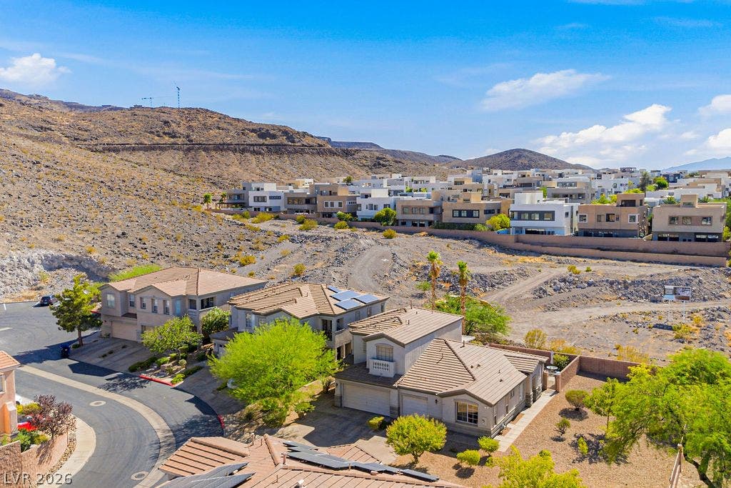 754 Solitude Point Avenue, Henderson, NV 89012 Rugged hillside topography surrounds this neighborhood of modern desert homes under clear blue skies.