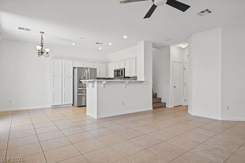 754 Solitude Point Avenue, Henderson, NV 89012 Tiled flooring and recessed lighting accent this spacious, open kitchen and dining area.