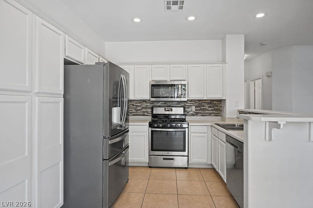 754 Solitude Point Avenue, Henderson, NV 89012 Recessed lighting and a tile floor anchor this functional kitchen layout.