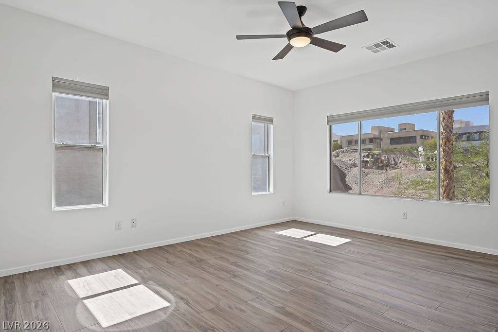 754 Solitude Point Avenue, Henderson, NV 89012 Generous windows frame neighborhood views across this versatile living space featuring clean-lined wood flooring.