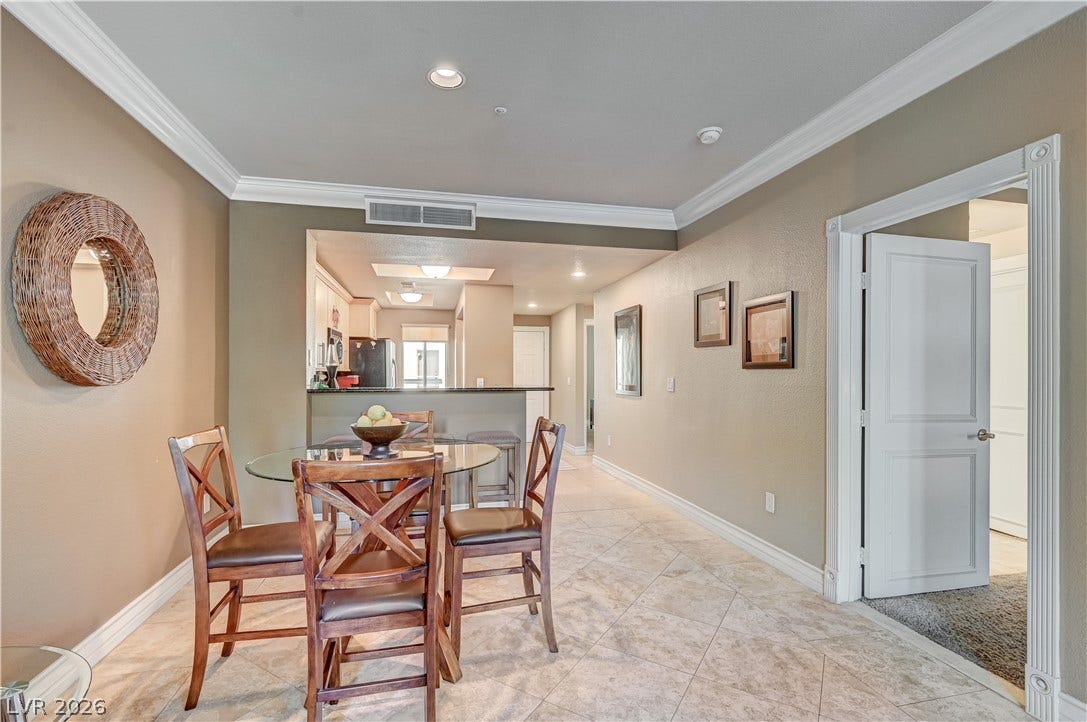 Crown molding and diagonal tile floors define this open dining area adjacent to the kitchen.