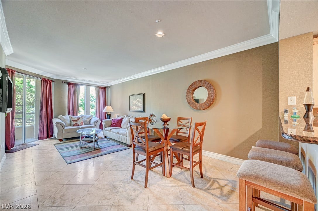 Polished tile flooring and elegant crown molding elevate this open-concept main living space.