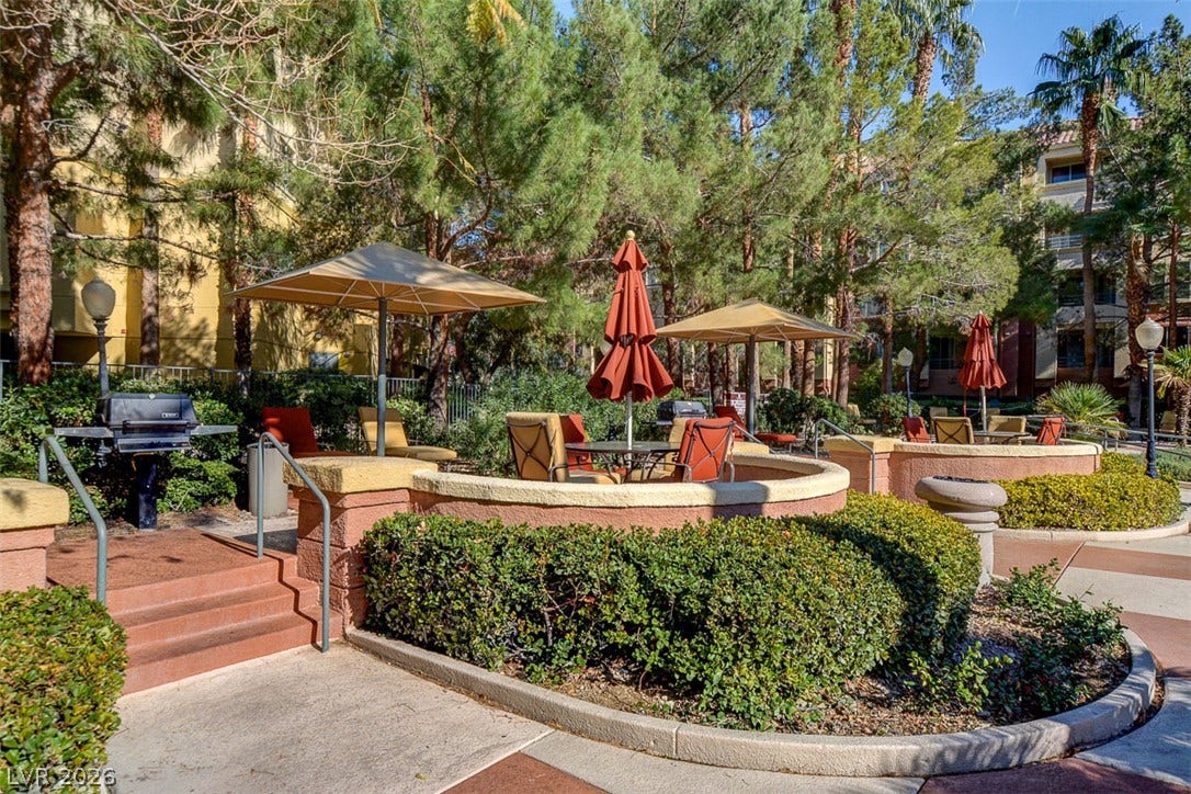 Mature trees frame a welcoming common courtyard featuring built-in seating ledges and barbecue grills.