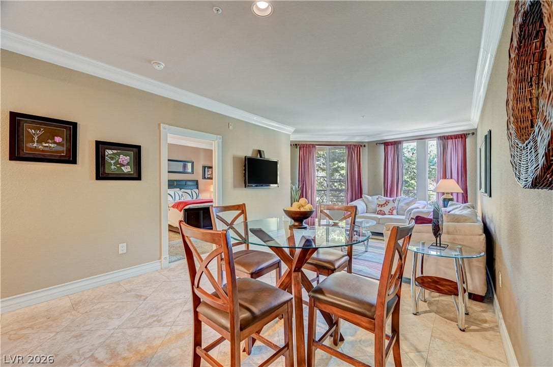 Polished tile flooring and classic crown molding accent this bright, open living space.