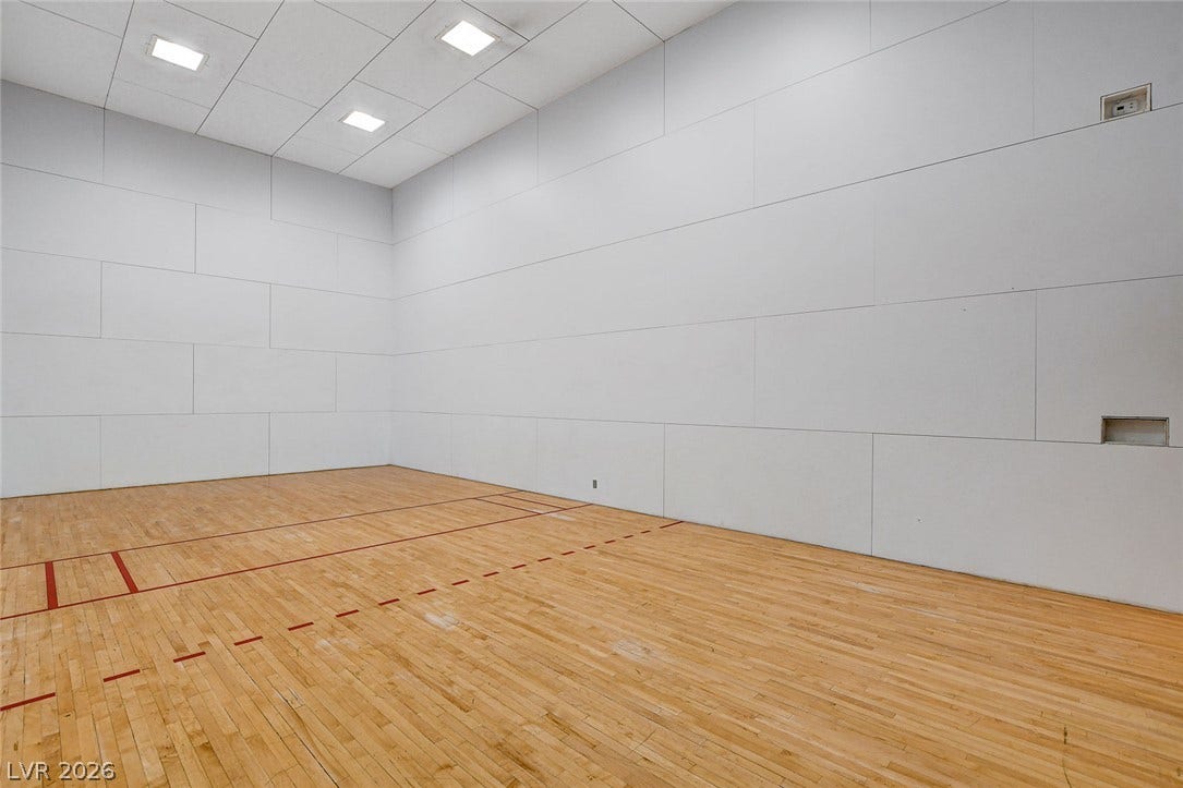 Polished hardwood floors and high walls define this indoor athletic court.