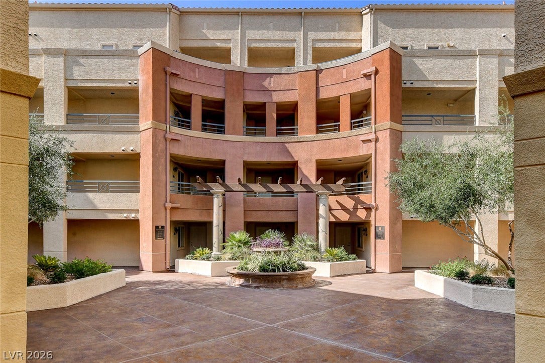 An elegant stucco exterior frames a central courtyard with integrated planters and a decorative pergola.