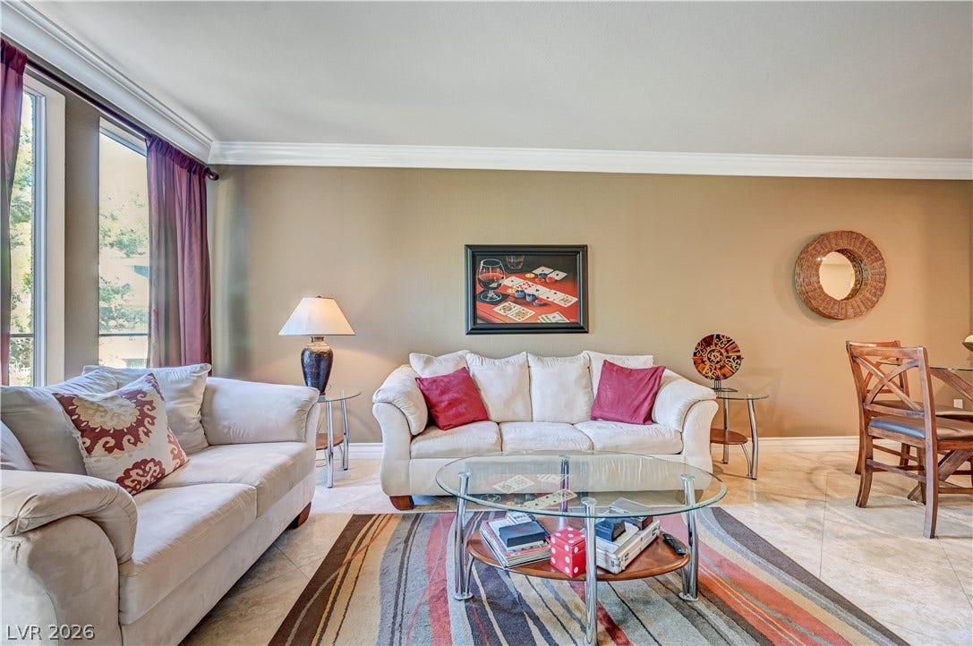 Polished tile flooring and detailed crown molding enhance this inviting open living space.