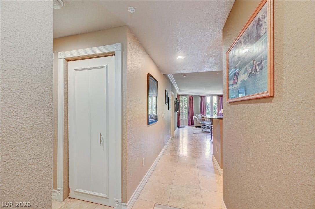 Gleaming tile floors guide the eye down a welcoming hallway toward the main living space.