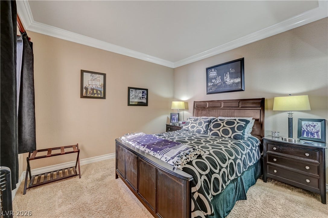 Crisp crown molding accents the tray ceiling in this carpeted bedroom.