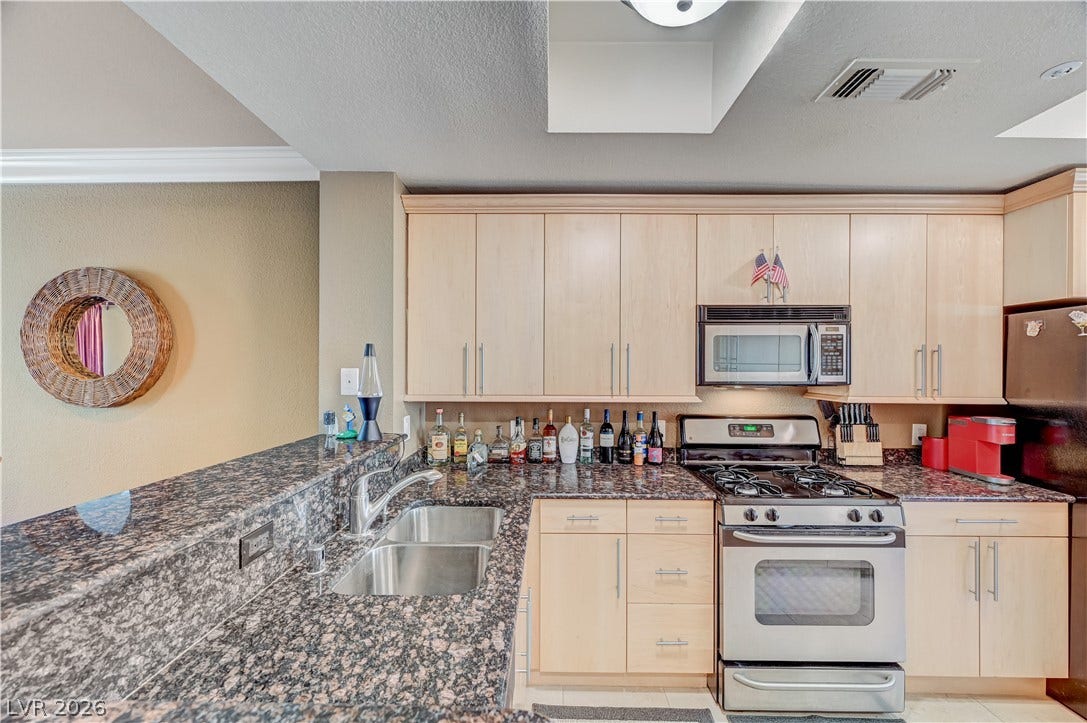 Ample cabinetry and stone countertops define this functional kitchen workspace.