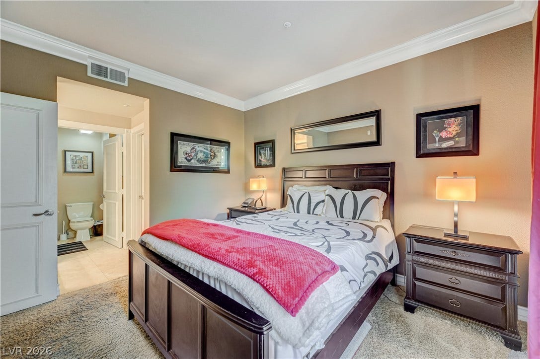 Elegant crown molding and plush carpeting define this comfortable bedroom suite with an adjoining bath.