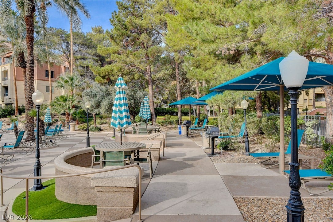 Paved pathways wind through beautifully landscaped common areas shaded by mature trees.