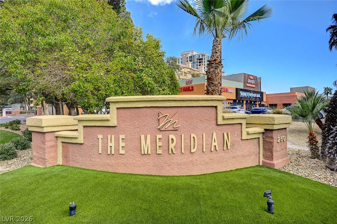 Welcoming community signage stands amid manicured landscaping under a bright desert sky.