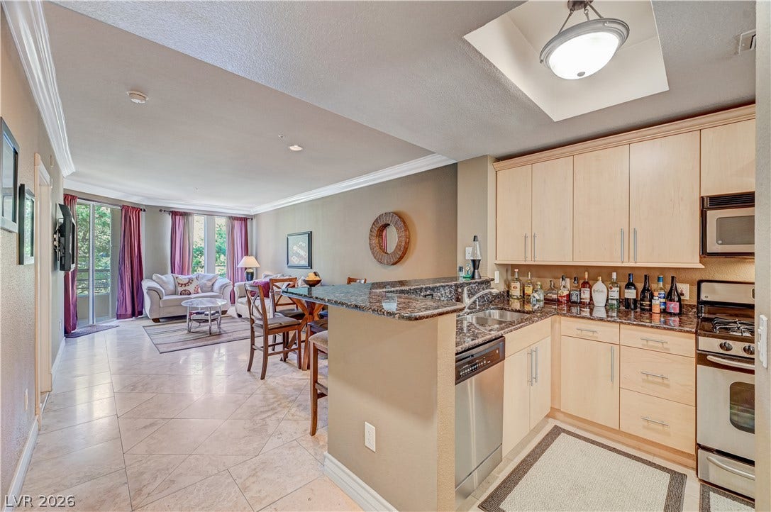 Granite countertops and light wood cabinetry anchor this functional open kitchen.