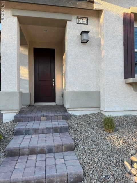 10764 Canary Blossom Avenue, Las Vegas, NV 89129 Inviting stone steps lead directly to a sheltered entrance framed by classic stucco pillars.