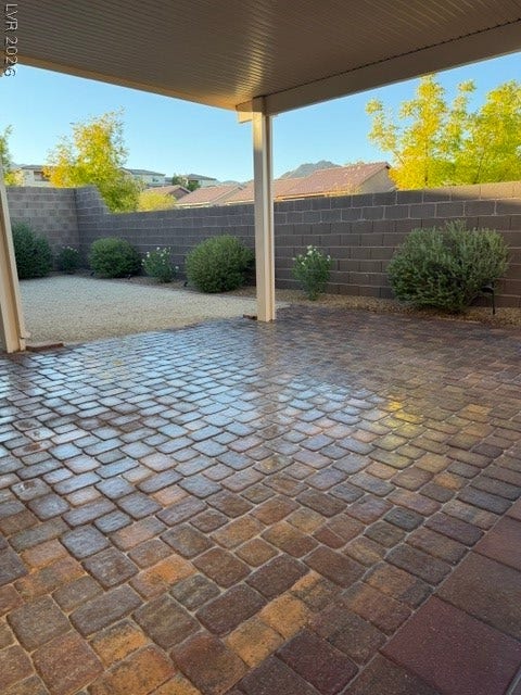 10764 Canary Blossom Avenue, Las Vegas, NV 89129 A spacious brick paver patio sits under a covered awning alongside a block wall fence.