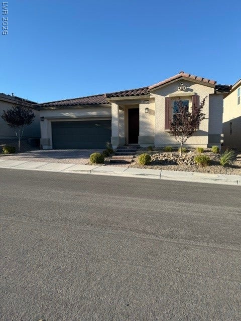 10764 Canary Blossom Avenue, Las Vegas, NV 89129 A stucco exterior and tile roof offer classic architectural appeal under clear blue skies.