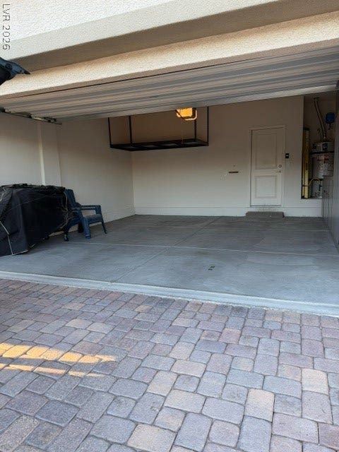 10764 Canary Blossom Avenue, Las Vegas, NV 89129 An attached garage features concrete flooring and leads directly to a paver block driveway.