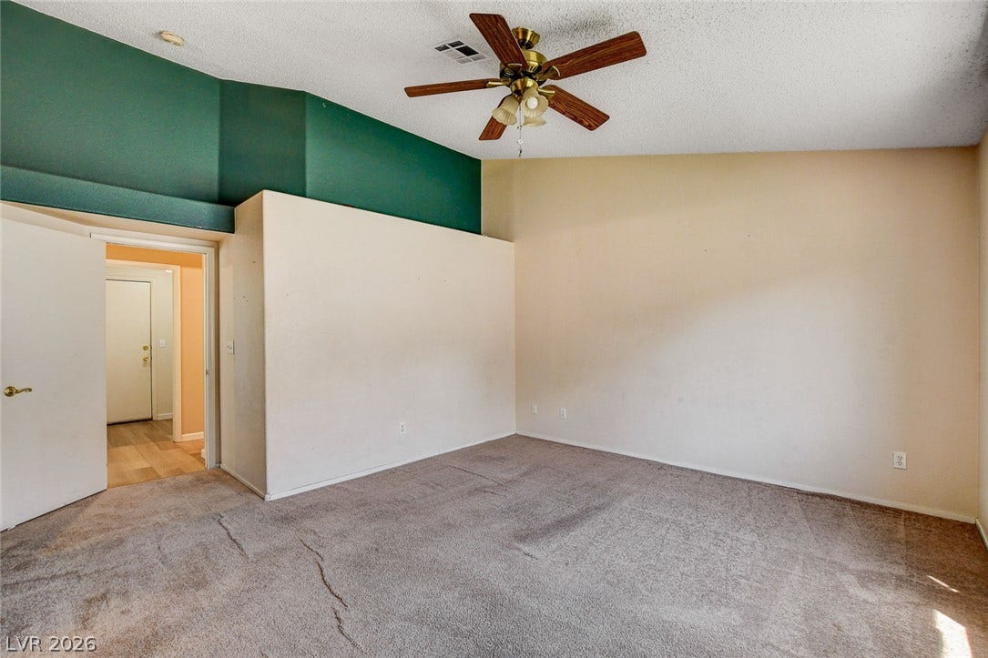 811 Rio Poco Court, Henderson, NV 89015 A spacious carpeted bedroom features a vaulted ceiling and an open doorway to the hall.