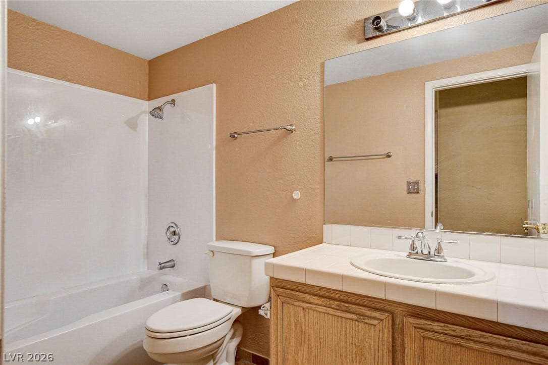 811 Rio Poco Court, Henderson, NV 89015 Functional bathroom design incorporates a tiled vanity countertop alongside a standard tub and shower setup.
