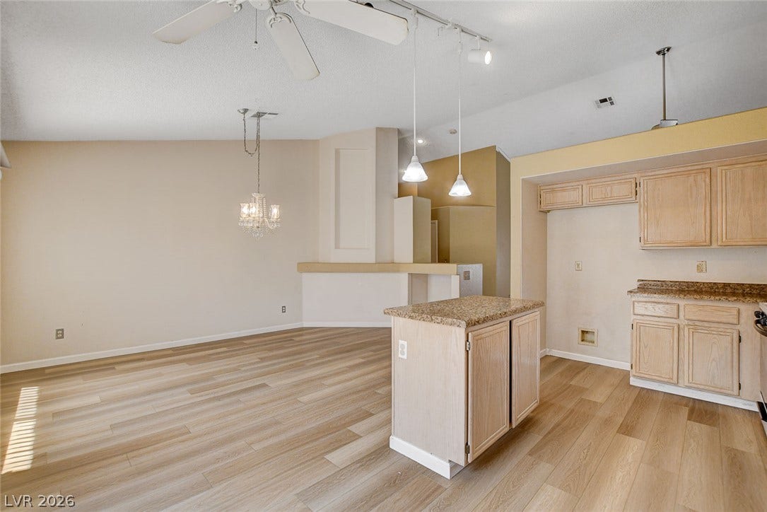 811 Rio Poco Court, Henderson, NV 89015 Gleaming wood-inspired floors flow through this open-concept kitchen and dining area under vaulted ceilings.