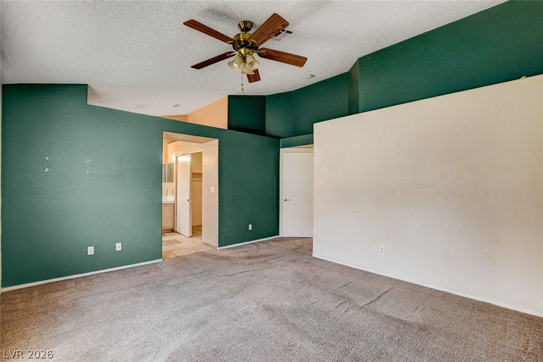 811 Rio Poco Court, Henderson, NV 89015 A spacious bedroom features vaulted ceilings and carpet flooring.