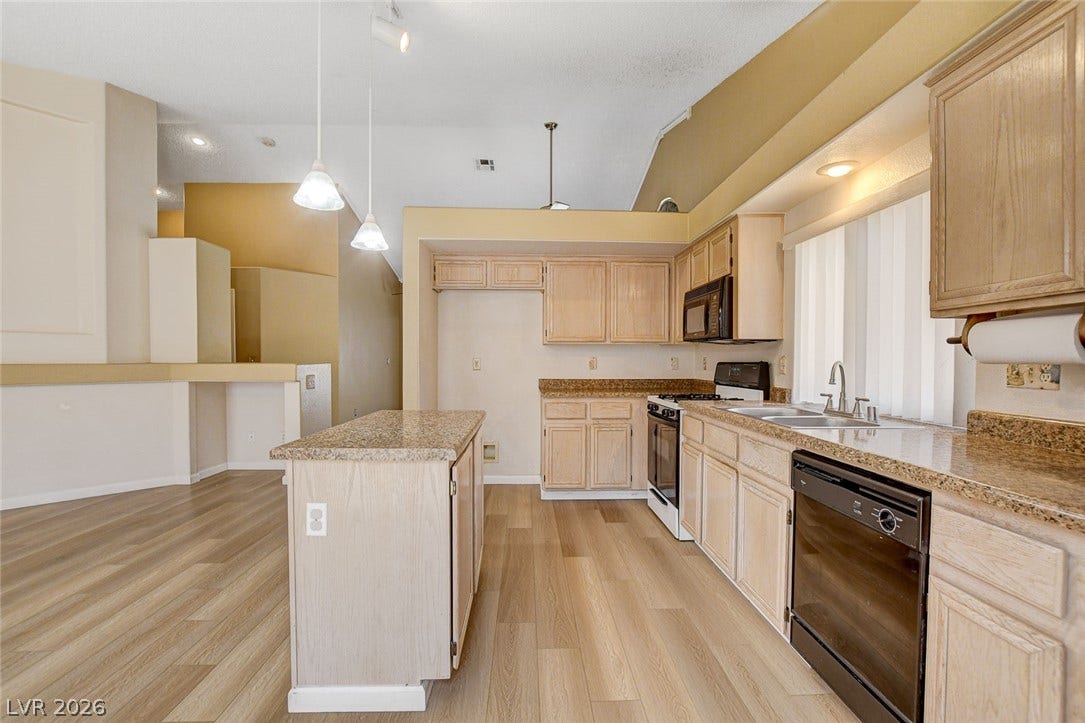 811 Rio Poco Court, Henderson, NV 89015 An open kitchen layout showcases wood-look flooring under soaring vaulted ceilings.