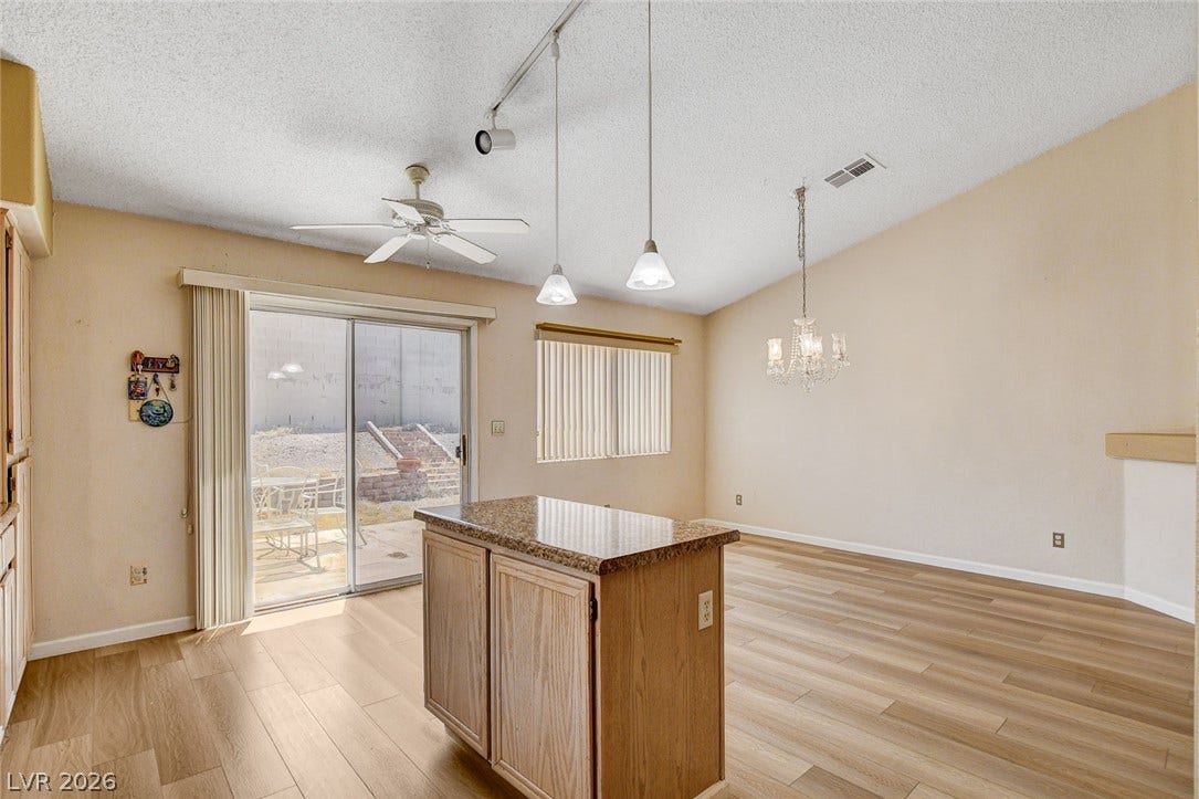 811 Rio Poco Court, Henderson, NV 89015 Sliding glass doors open to the outdoors from this versatile space with warm wood floors.