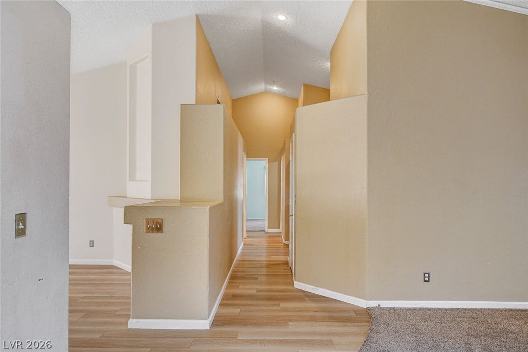 811 Rio Poco Court, Henderson, NV 89015 Soaring vaulted ceilings and warm wood-look flooring define this welcoming architectural entryway.