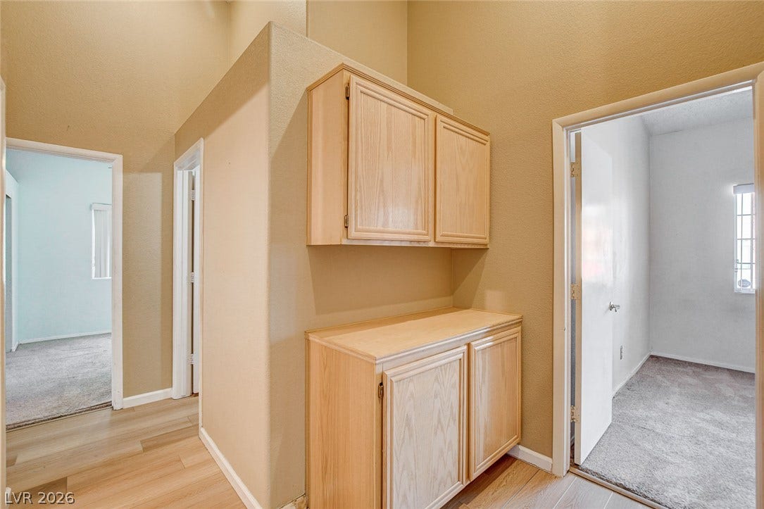 811 Rio Poco Court, Henderson, NV 89015 High vaulted ceilings and built-in wood cabinetry anchor this central transition hallway.
