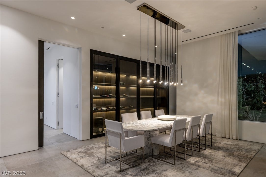 A chic dining space offers a contemporary chandelier and built-in wine storage, perfect for entertaining.