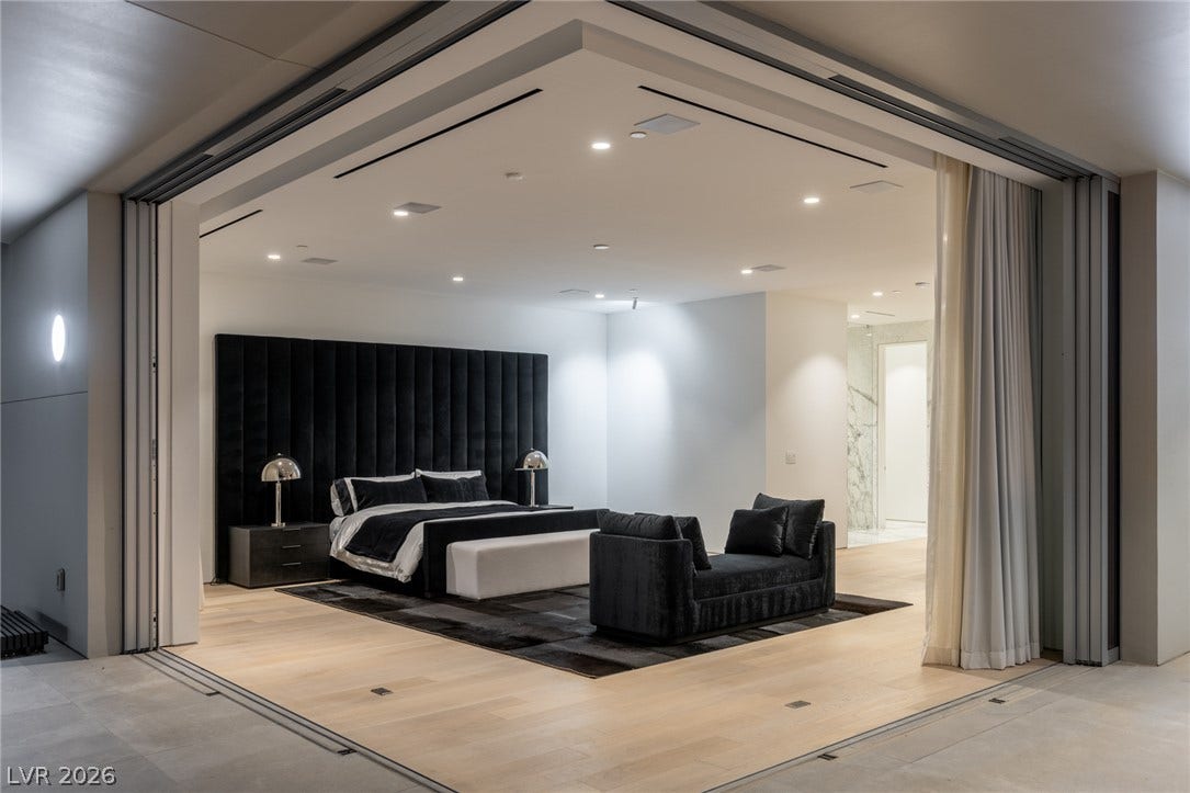 A well-lit bedroom features hardwood flooring and an inviting ambiance, separated by a unique sliding wall system.