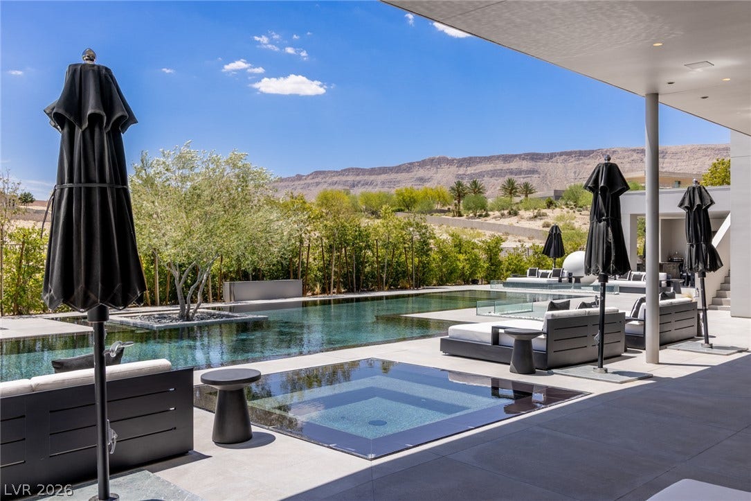 An oasis of clear waters and lounging areas unfolds against a captivating desert mountain backdrop.
