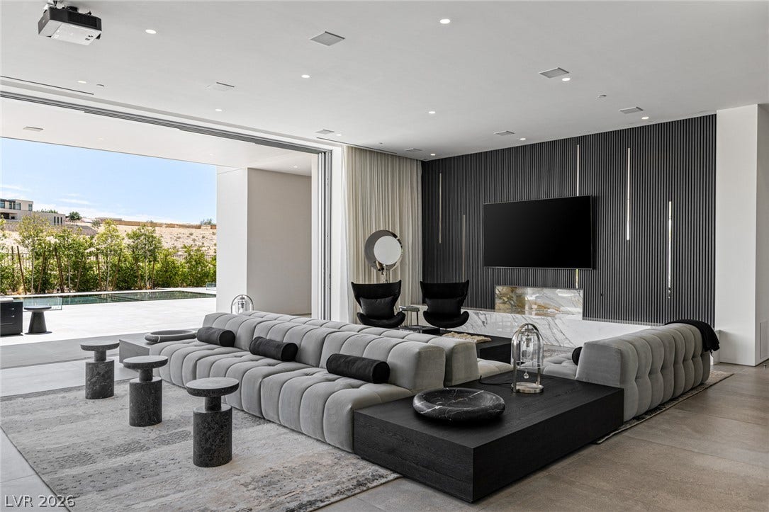 A spacious living room offers an inviting atmosphere with an outdoor pool view.