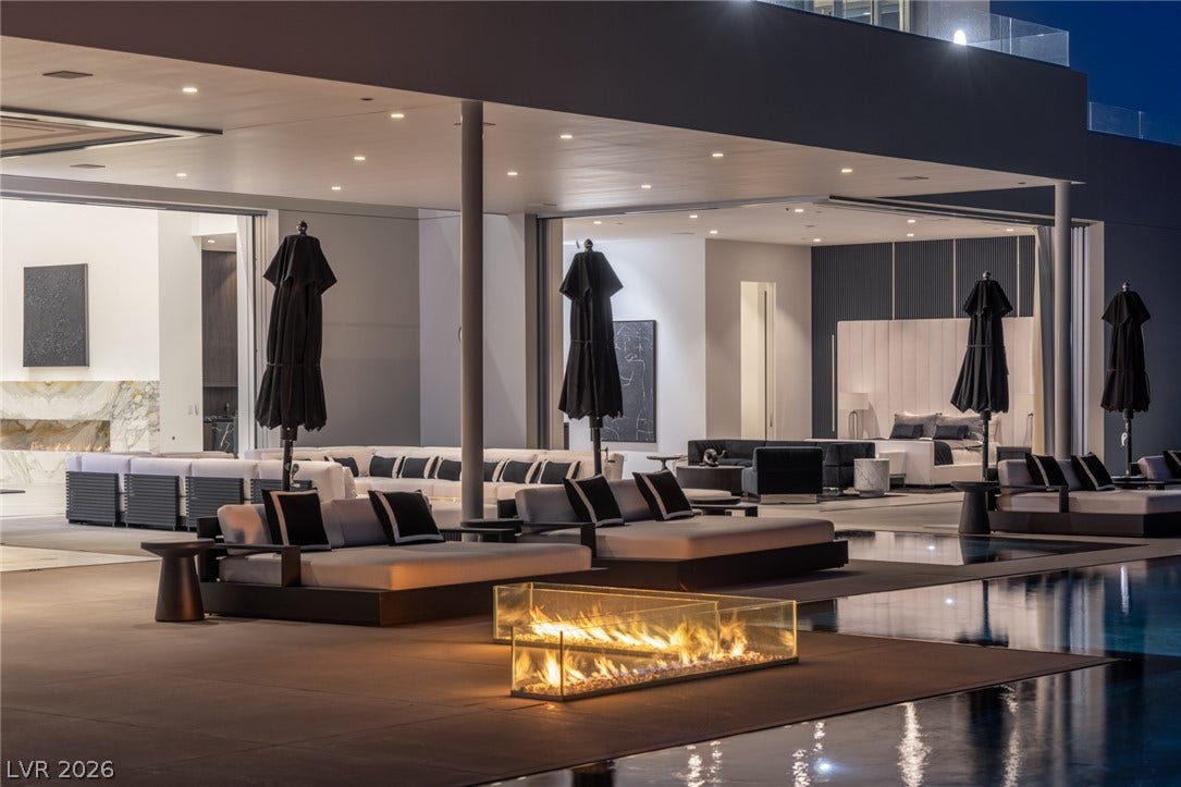 An inviting outdoor living space features a linear fire pit and an adjacent pool, perfect for evening gatherings.