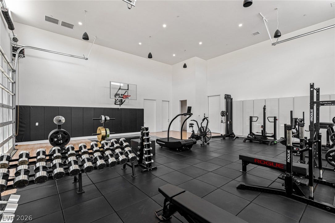 An adaptable space equipped for diverse fitness activities, featuring robust workout equipment and high ceilings.